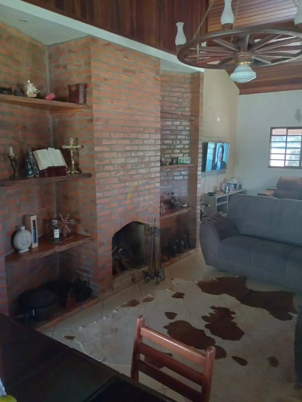 Sala de estar com lareira de tijolos do sítio à venda em Torrinha/SP