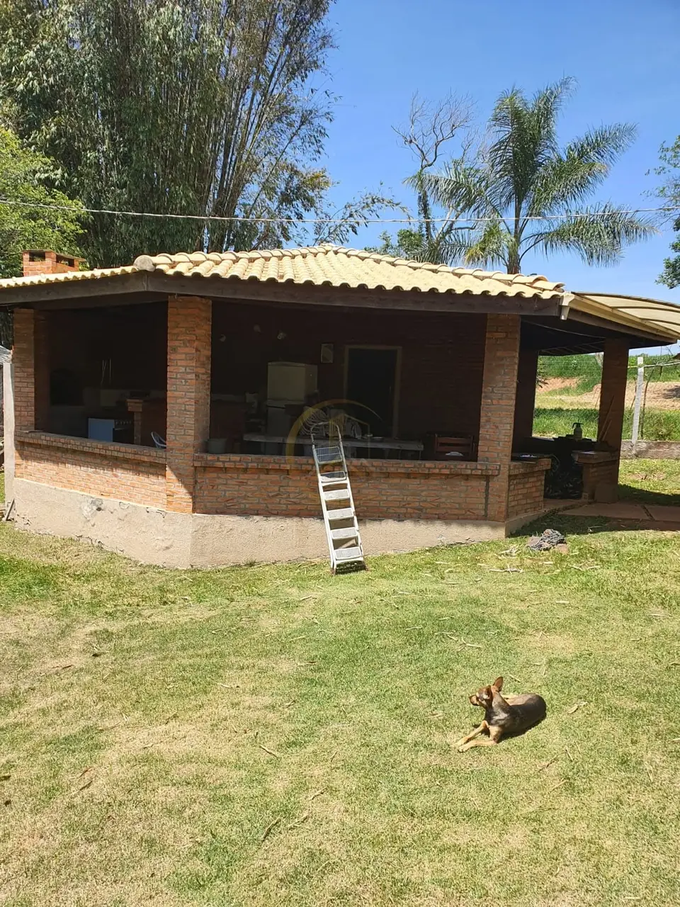 Construção com varanda e gramado ao redor do sítio à venda em Torrinha/SP