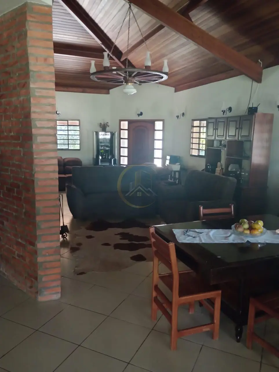 Sala com estrutura de madeira aparente no teto do sítio à venda em Torrinha/SP